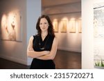 Small photo of Pride, arms crossed and portrait of a woman at an art gallery for an exhibition. Creative, culture and a museum manager with management of paintings, collection and curator of pictures at a studio