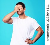 Small photo of Man, face palm and mistake in studio with thinking, regret and anxiety for fail by blue background. Young guy, student and cover eyes with stress, memory and shame for bad decision with depression