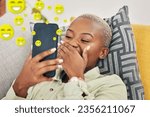 Black woman on sofa with phone, laughing and emoji on social media, message or video online. Happy face, smile and internet, girl on couch with digital app on smartphone and funny viral meme in home.