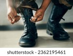 Small photo of Hands tie shoes, closeup and soldier in army getting ready to start war, battle or fight. Boots, man tying laces in military and veteran preparing gear for training, exercise and workout to travel