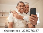 Small photo of Senior couple, home and smile with smartphone for video call, mobile streaming and scroll on social media in retirement. Happy old man, woman and hug with phone for selfie, reading news app and relax