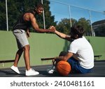 Small photo of You played so well dude. Shot of two sporty young men shaking hands on a basketball court.