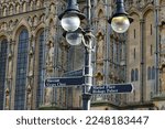 Small photo of Wells, Somerset, uk. January 11th 2023. Vicars close, Wells. Wells Cathedral signpost with the cathedral behind. Signs for Bishops palace, Market place and Vicars close. Focus on the black signpost.