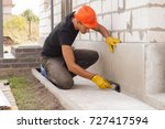 worker applies bitumen mastic on the foundation