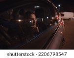 Woman portrait in a car at the night relaxing looking through window
