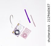 Small photo of 90s Nostalgia. Cassette tape and purple pencil levitating on a white background with shadow. Mangled tape. Retro concept.