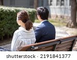 Small photo of A couple sitting on a park bench saying goodbye