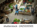 Small photo of Dar es Salaam Tanzania - Jan 26 2024: Fruit and vegetable traders wait for customers inside the Kisutu Market in Dar es Salaam, Tanzania in East Africa