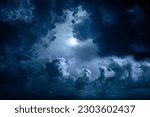 Night sky with moon light. Dramatic clouds in mystic moonlight. Large bright moon as concept of mystery, midnight, gothic time and spooky theme. Moody sky texture background.