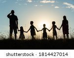 Silhouette of a happy large family at sunset.