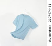 Small photo of Baby Blue tshirt with hanger. Flying cotton T-shirt isolated on white background