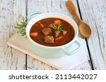 hearty homemade goulash soup on a wooden table