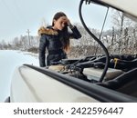 Small photo of A young woman stands on the deserted road, her car broken down. With a furrowed brow, she examines the engine, pondering the solution to her predicament, feeling a mix of frustration and worry.