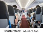 passenger seat, Interior of airplane with passengers sitting on seats and stewardess walking the aisle in background. Travel concept,vintage color