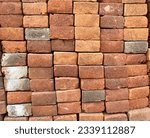 Small photo of The pile of bricks was disorganized and haphazardly stacked, lacking any semblance of order or structure. The bricks were of varying sizes and shapes, with some chipped or cracked.