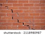 Small photo of Red Brick Wall with Large Crack and crumbling mortar