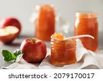 Small photo of Apple jam in a glass jar. Apple jam on a light background. Delicious natural marmalade.