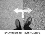 Businessman in black shoes standing at the crossroad making decision which way to go - easy or hard