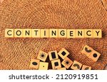 Small photo of CONTINGENCY word text from wooden cube block letters on braided rattan mats background. Contingency is an event or situation that might happen in the future, especially one that could cause problems.