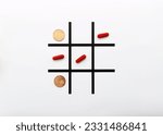 Small photo of Tic-tac-toe game with coins and pills or medicines