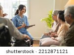Small photo of Group of asian senior people listening to young nurse. Psychological support group for elderly and lonely people in a community centre. Group therapy in session sitting in a circle in a nursing home.