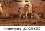 Small photo of Two astronauts in spacesuits walk toward research station, colony or scientific base on Mars. Manned exploring space mission on red planet. Futuristic colonization and space exploration concept.
