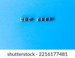 Small photo of New Year. Quote made from mettle letters on blue background. Creative concept for new year greeting card