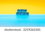 Small photo of New Year. Quote made from mettle letters on yellow and blue background. Creative concept for new year greeting card