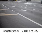 Small photo of Selective blur on lane markings with painted directional arrows on thru lanes on asphalt, on a city urban road used for heavy traffic, in Europe, abiding by european standards.