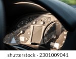 Selective blur on an analog car dashboard with the instrument panel, such as the RPM indicator, the speedometer and the fuel gauge indicating an empty tank, in a vintage car.