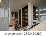 Small photo of London, England, United Kingdom - July 31, 2022. British Library interior. A showcase of books, a large bookshelf packed with books. A truly grand display in this modern and trendy public library.