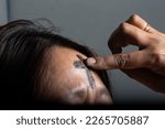 Small photo of the symbol of a cross made of ashes placed on a woman's forehead during Ash Wednesday celebrations, Medan, February 23, 2023