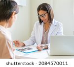 African american female doctor in uniform prescripting treatment to faceless woman patient. Physician discussing medical diagnosis with and prescribing medicine