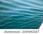 Small photo of Exciting a group of whale sharks swim beneath the blue sea foaming through the waves. The sea is clear and calm and you can see schools of fish underwater. blue sea background.