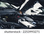 Small photo of Close-up shot of unrecognisable man wearing black glove inspecting car engine and interior of hood of car. Garage work. Horizontal indoor shot. High quality photo