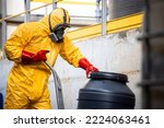 Small photo of Chemical worker in protective suit and gas mask working with hazardous materials and toxic waste in production plant.