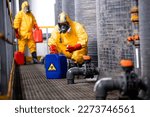 Small photo of Trained factory workers carefully handling toxic and dangerous biohazardous waste in chemicals factory.