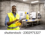 Portrait of African American civil engineer or construction worker holding tablet computer.