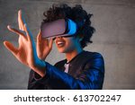 Amazed young woman touching the air during the VR experience. Horizontal studio shot.