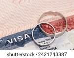 Wedding rings on passport with us visa as concept of marriage of convenience
