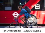 Small photo of London, UK - June 22, 2022: Young woman cycling at work by bike. People cycling into the City of London