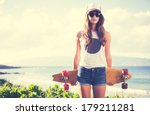 Beautiful hipster girl with skate board wearing sunglasses