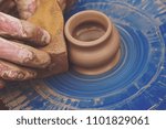 Small photo of Potters hands shaping a bowl out of clay. Man cleans with sponge pottery on a Potter's wheel. The final stage of manufacture of the jug