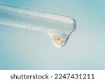 Small photo of A fetus on a blue background in a drop of liquid. a genetic experiment with the creation of a new life. The concept of cloning.