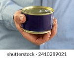 Tin can with ring in male hand. Close up an empty label for design and text. Copy Space