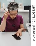 Small photo of Woman adjusting hearing aid through smartphone. Hearing loss treatment and small device for correction. Telehealth. heathy care, Manage hearing aid settings via smartphone Problem to hear.