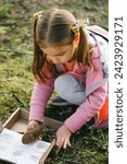 Small photo of Scavenger hunt for kid in the park. Girl learning about environment. Natural education activity for World Earth day. Exploring in spring.