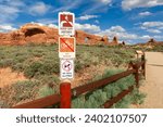 Visitor Restriction Sign near The Windows Viewpoint and Trail in Arches National Park, Utah, United States. Keep off arches, No bikes, and No pets signs.
