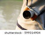 Photographer with mirrorless camera. Standing outdoors with the camera hanging on the shoulder
