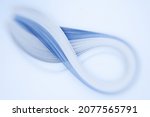 Small photo of A set of blue quilling strips shot with a creative lens giving selective, shallow depth of field, shaped as an infinity sign with attractive defocussed background bokeh and space for text meta